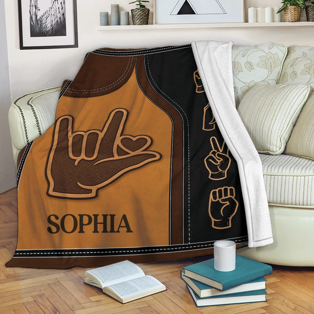 Sign language blanket draped over a couch with bold hand gesture artwork