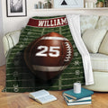 American football throw blanket styled across a living room sofa with sports artwork