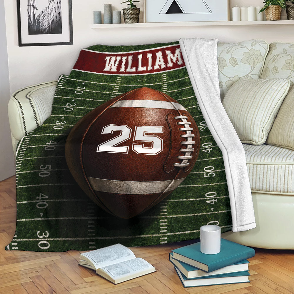American football throw blanket styled across a living room sofa with sports artwork