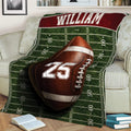 Football blanket draped over a sofa featuring a large football and green field design