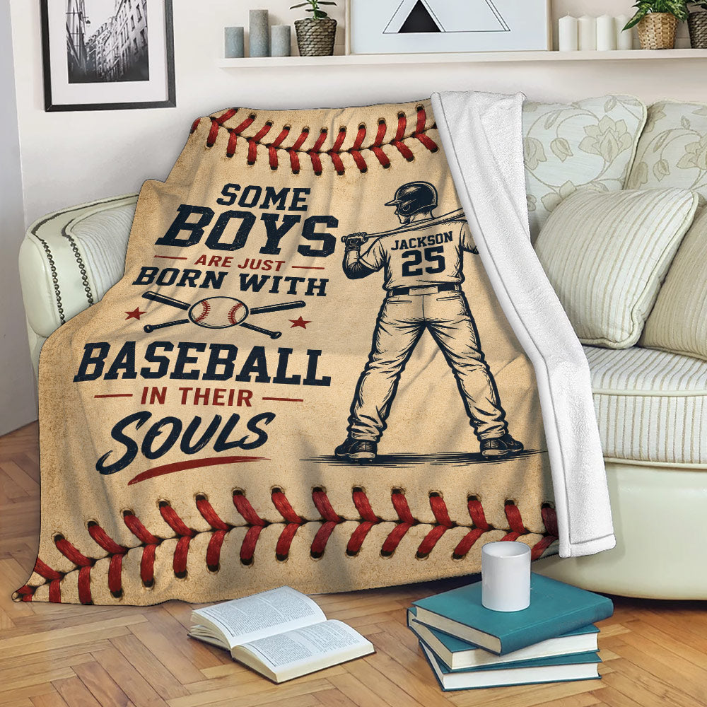 Baseball throw blanket draped over a sofa with vintage player artwork, crossed bats, and red stitched borders
