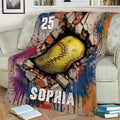 Colorful softball throw blanket displayed on a couch with dramatic cracked-wall ball artwork
