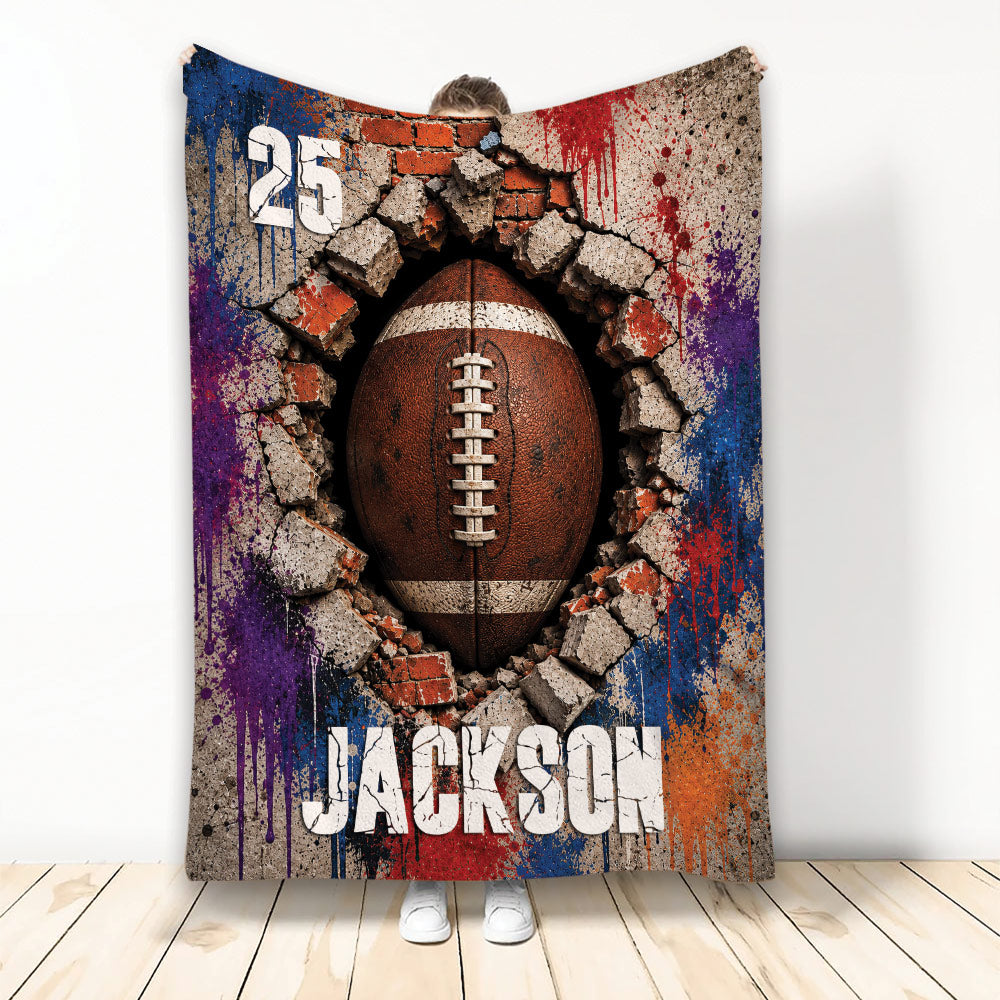 Football throw blanket featuring a dramatic ball breaking through a cracked wall with bold colorful artwork