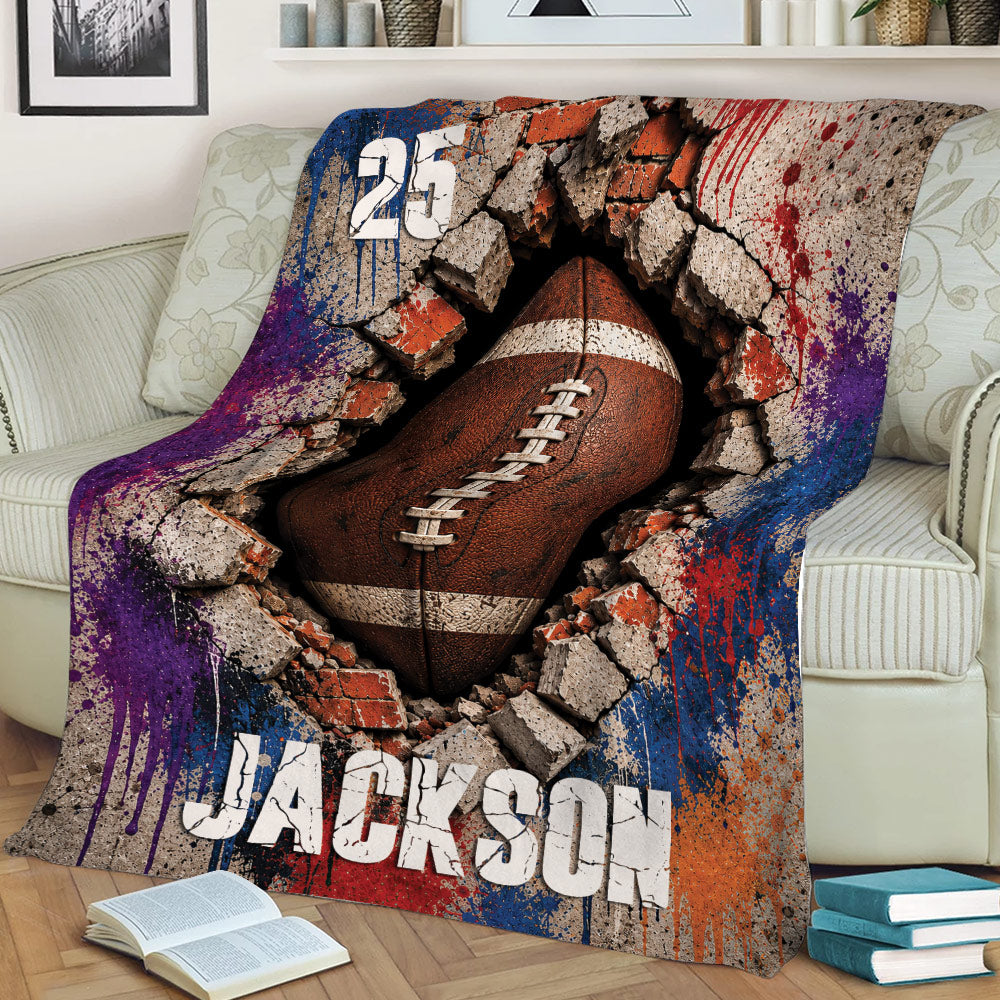 American football blanket draped over a sofa with a bold cracked-wall design and colorful gridiron artwork