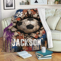 Soccer blanket draped over a sofa, featuring rugged ball artwork and a multicolor grunge background