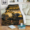 Construction excavator throw blanket displayed across a couch with dramatic yellow and black work-zone artwork