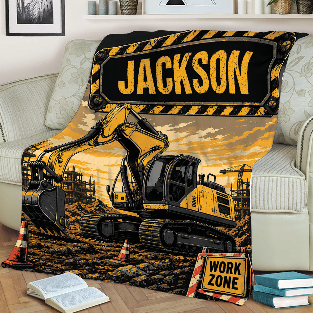 Construction truck throw blanket styled on a sofa with tracked excavator artwork, traffic cones, and building-site scenery