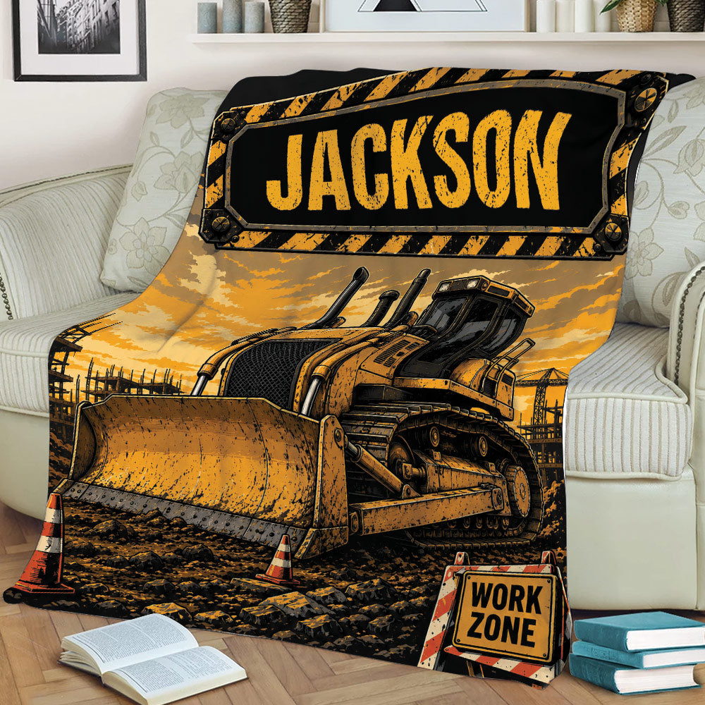 Construction truck throw blanket draped over a sofa with a detailed bulldozer scene and black and yellow work-zone design