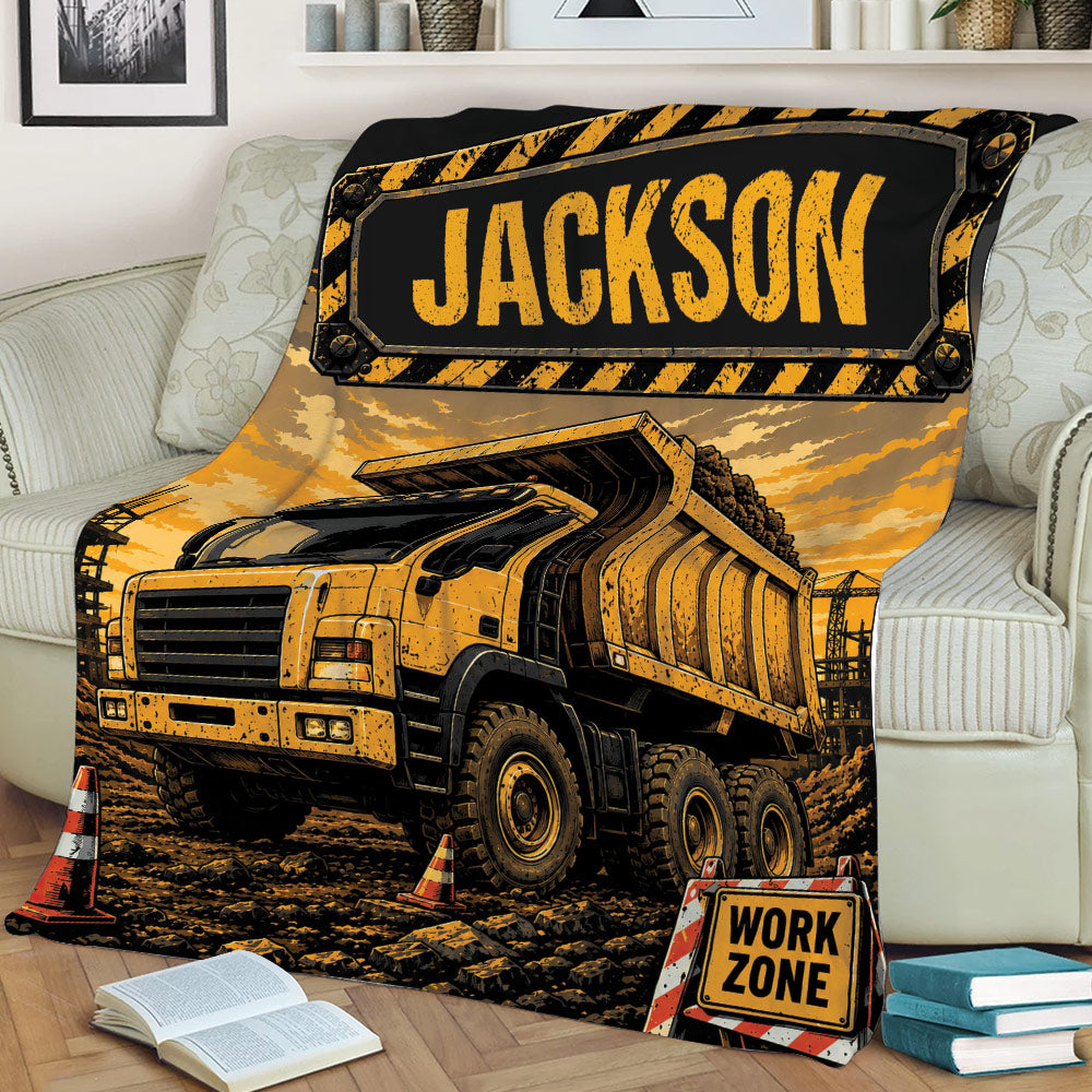 Dump truck blanket styled over a sofa with rugged construction equipment and work-zone artwork