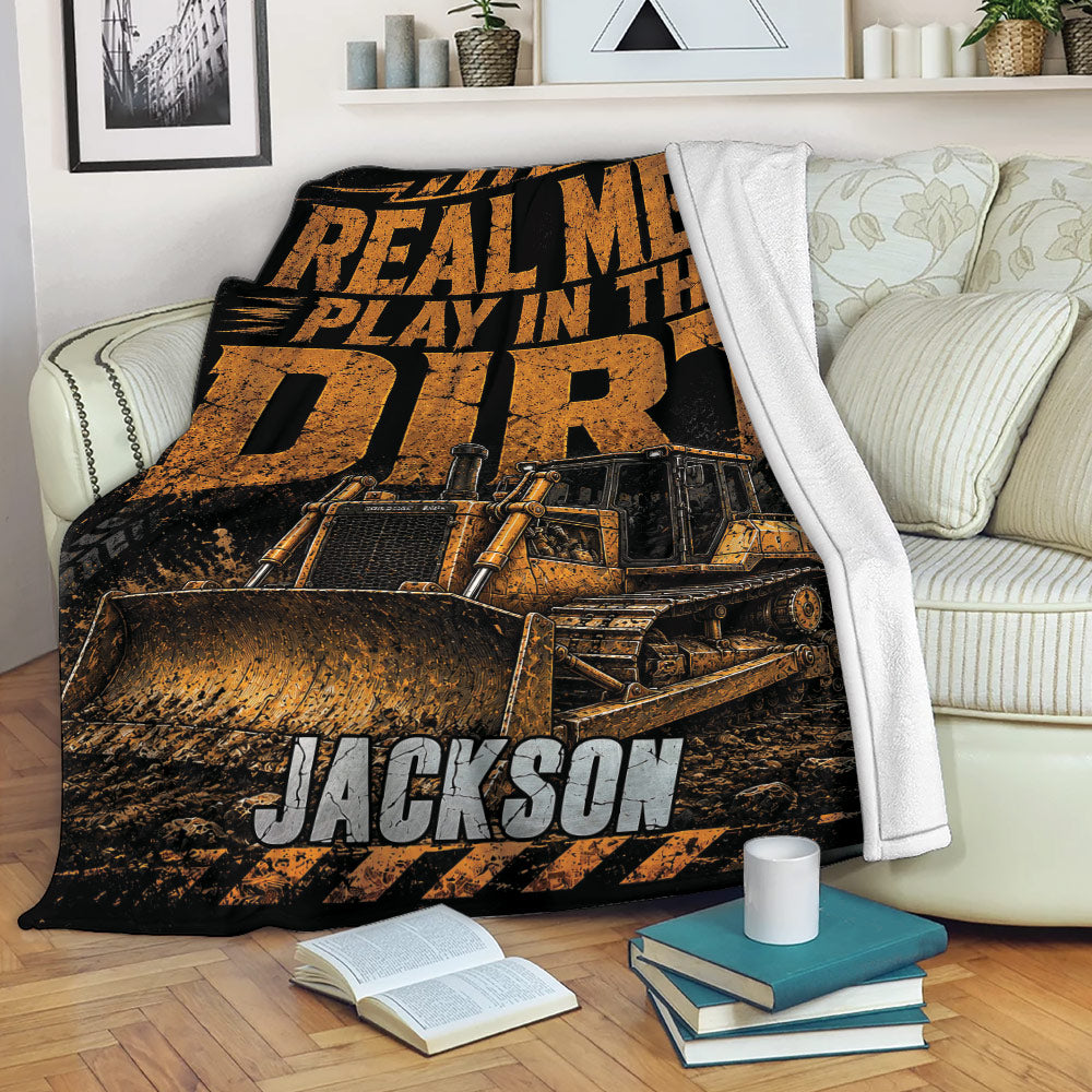 Construction truck throw blanket displayed on a sofa with bold bulldozer artwork and industrial colors