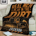 Bulldozer construction blanket draped over a couch with bold black and orange artwork