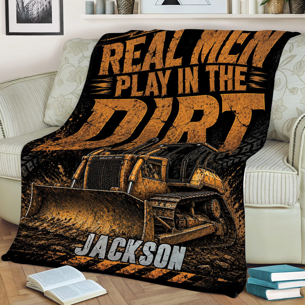 Bulldozer construction blanket draped over a couch with bold black and orange artwork