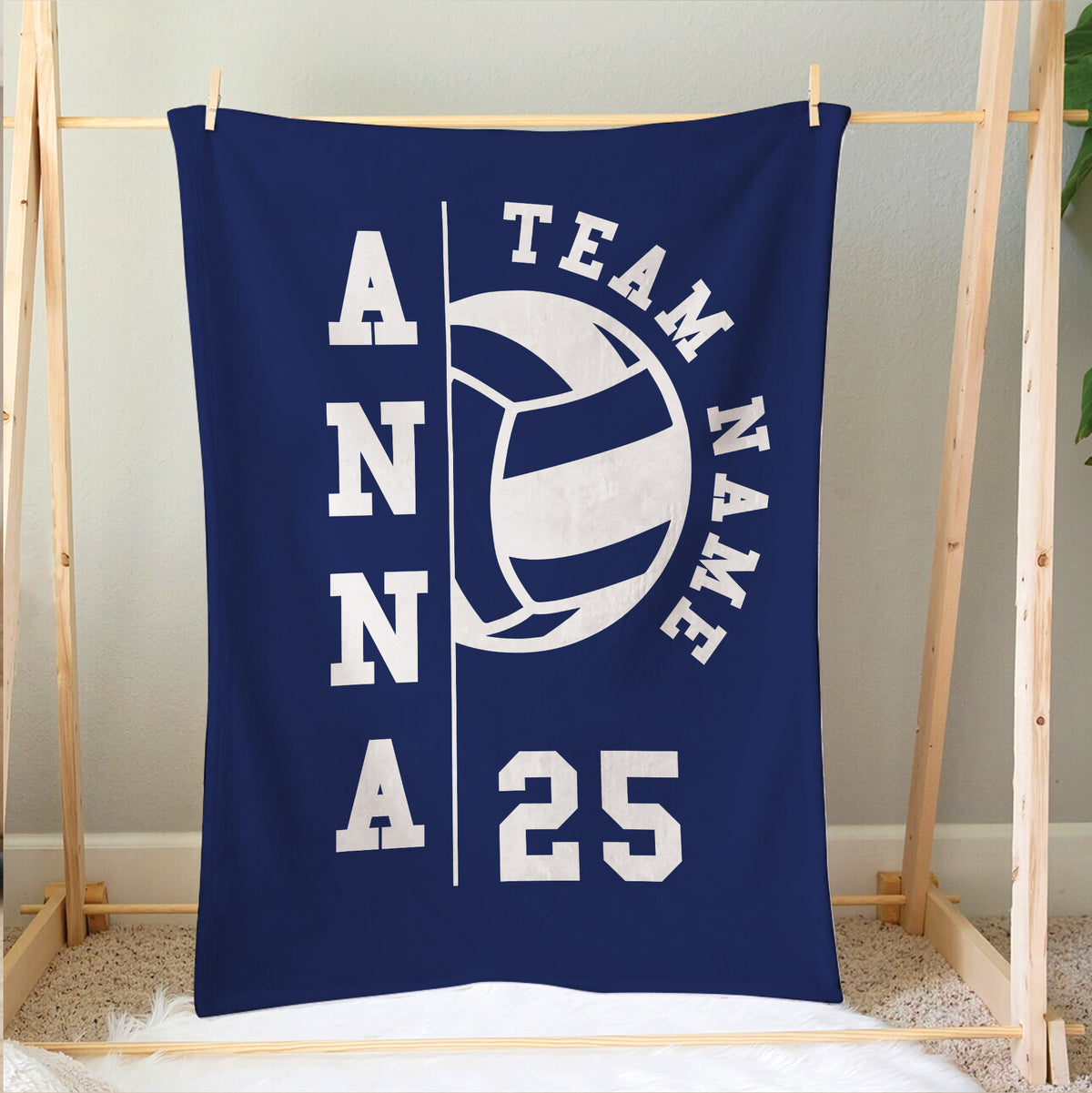 Blue volleyball blanket hanging on a wooden frame with bold team sports artwork