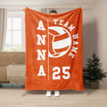 Orange volleyball team throw blanket displayed in a living room with bold white sports artwork
