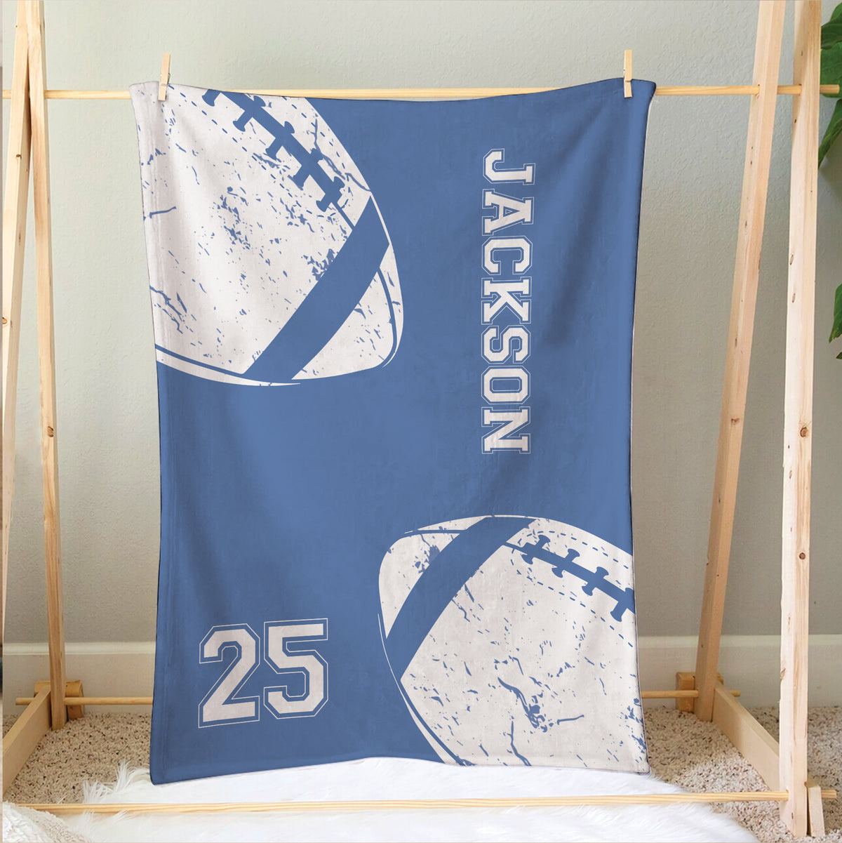 Football throw blanket displayed on a wooden bed frame with blue and white sports artwork
