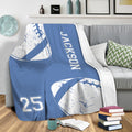 Blue football blanket draped over a sofa in a cozy living room