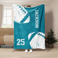 Teal football throw blanket displayed upright with white football artwork and jersey-style numerals