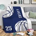 Navy basketball blanket draped over a sofa in a casual sports room setting