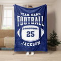 Blue football throw blanket displayed in a living room with bold collegiate-style sports artwork