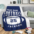 Blue football throw blanket draped over a sofa for cozy sports-themed living room decor