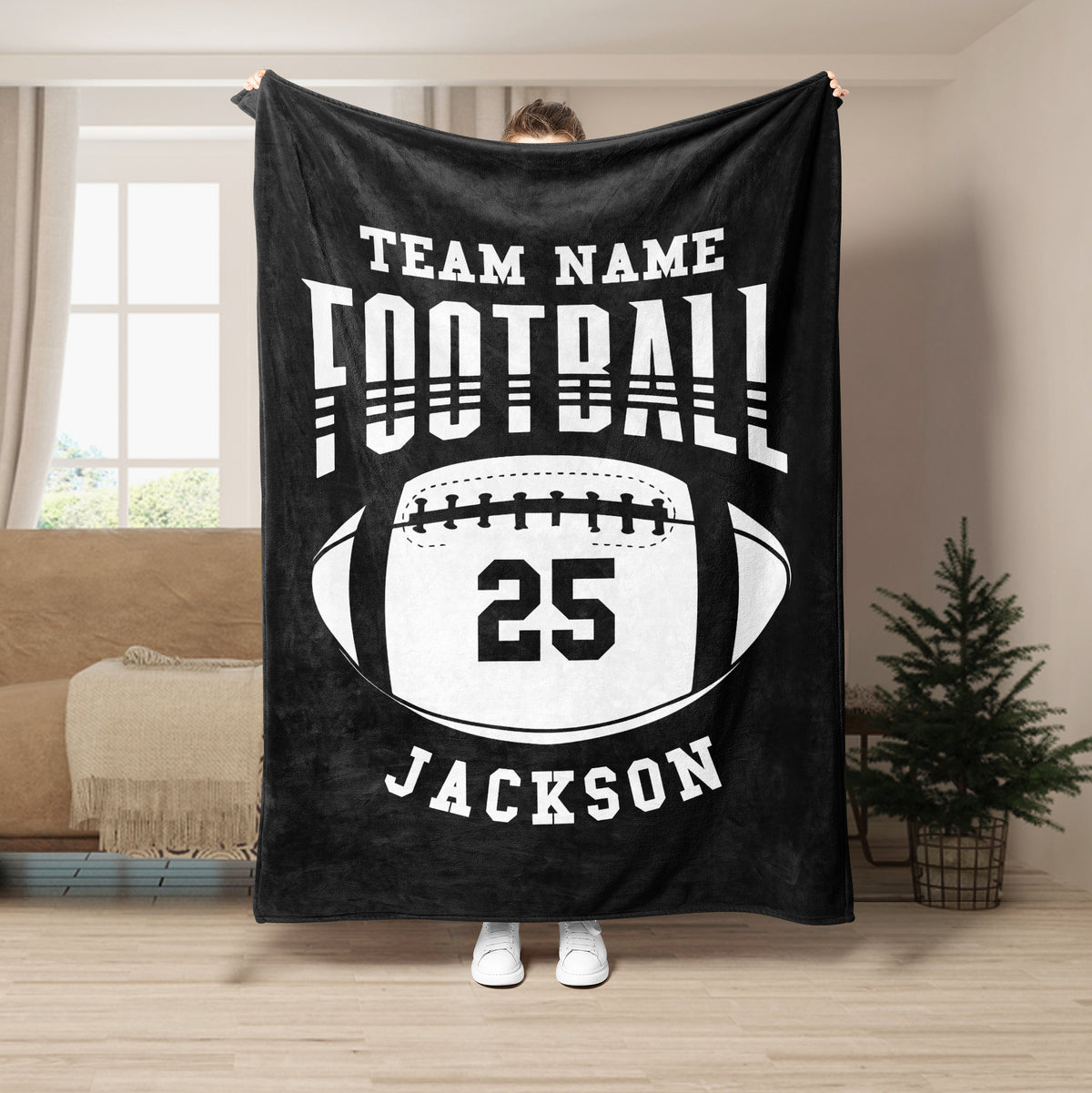 Black football throw blanket displayed in a living room with contrasting white sports artwork