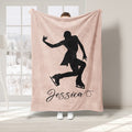 Blush ice skating blanket featuring a black silhouette of a skater gliding across the design