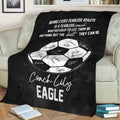 Black soccer throw blanket displayed over a sofa with soccer ball artwork and coach appreciation message