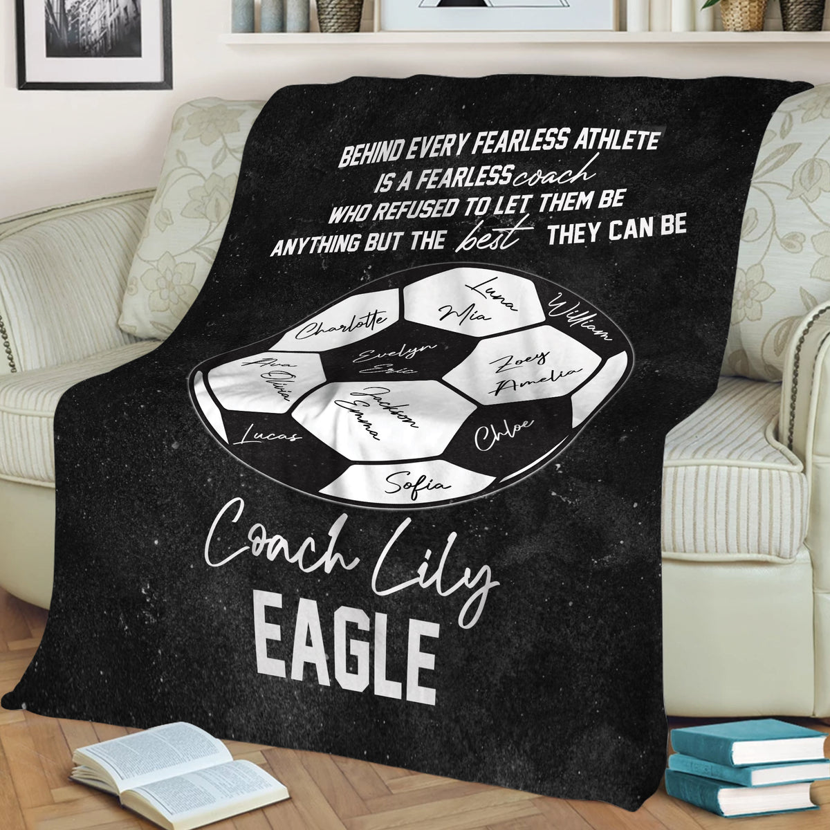 Black soccer throw blanket displayed over a sofa with soccer ball artwork and coach appreciation message