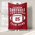 Red football throw blanket featuring bold white sports lettering and a large oval football design