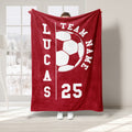 Red soccer throw blanket featuring a large white soccer ball graphic and bold team-inspired sports design