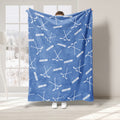 Light blue hockey throw blanket displayed with white sticks and puck pattern