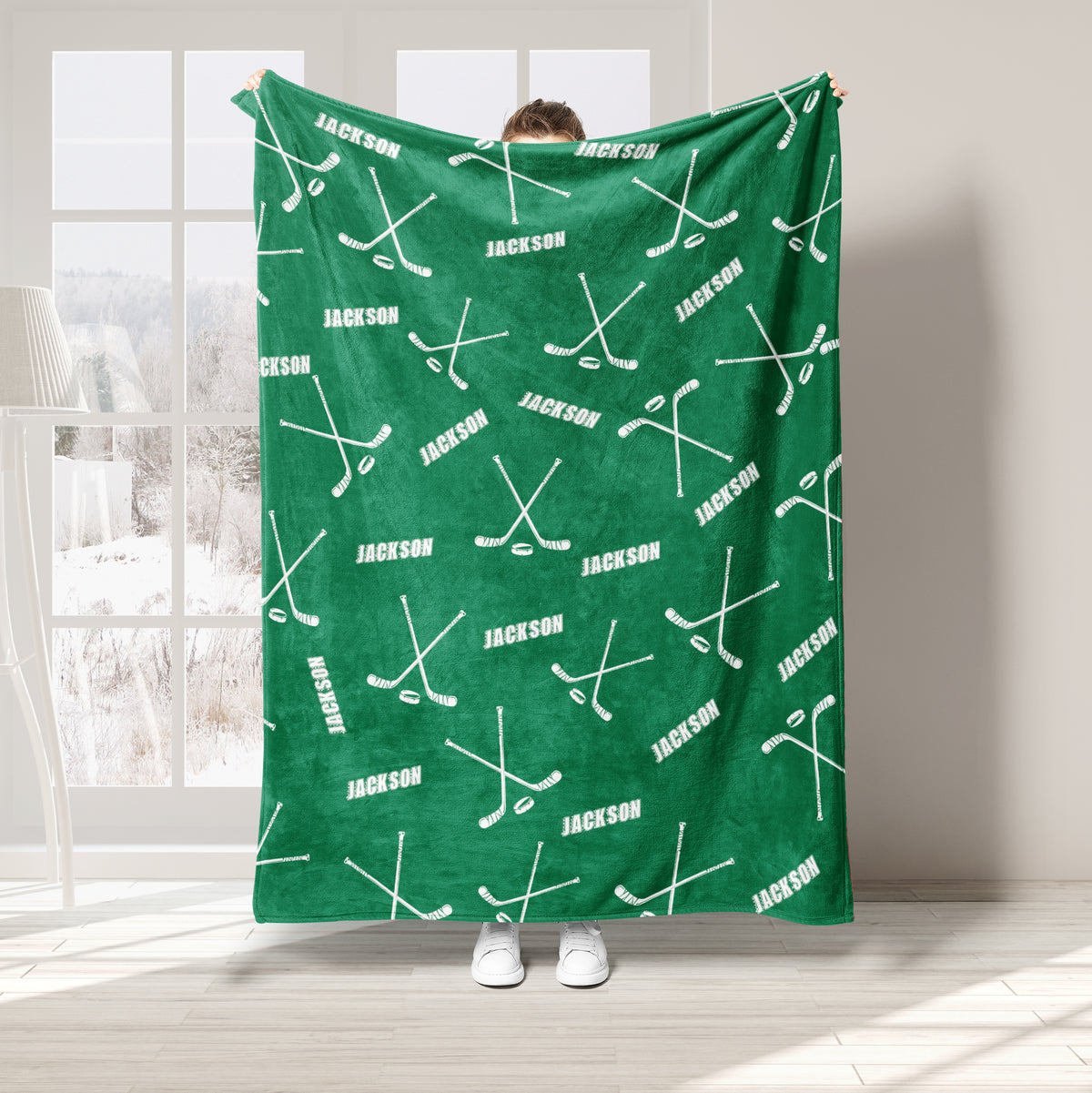 Green hockey throw blanket displayed with repeating hockey stick and puck artwork