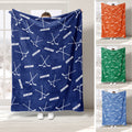 Navy hockey throw blanket displayed with repeating crossed sticks and puck artwork