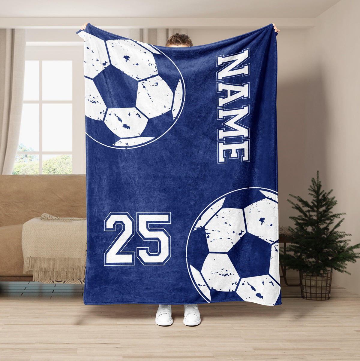 Blue soccer throw blanket displayed in a living room with bold ball graphics and athletic-inspired design