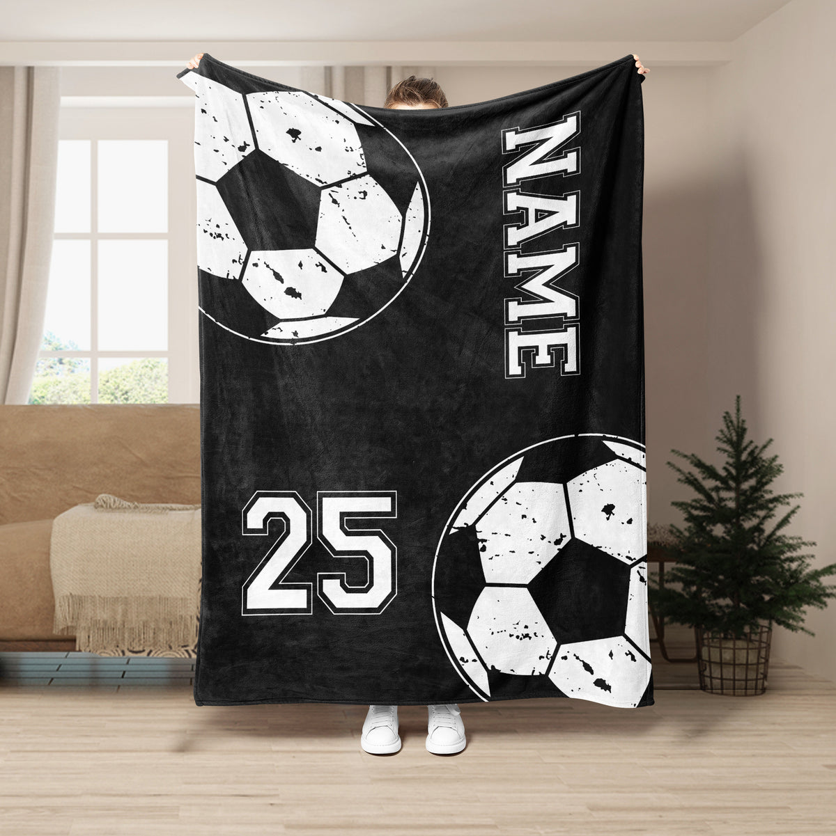 Black soccer throw blanket displayed in a room with white ball graphics and bold athletic-style artwork