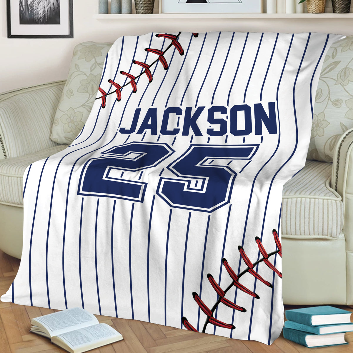 Baseball throw blanket draped over a chair, featuring pinstripes, stitched baseball details, and bold lettering