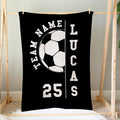 Black soccer blanket hanging on a wooden frame with bold white soccer ball artwork