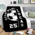 Black soccer throw blanket draped over a sofa in a modern living room