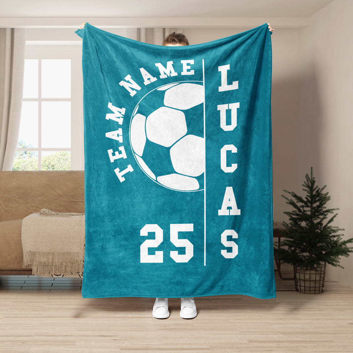 Teal soccer throw blanket displayed with large white soccer ball artwork in a living room