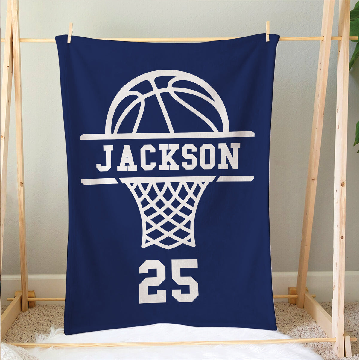 Navy basketball blanket hanging on a wooden frame with a large white basketball hoop graphic