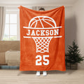 Orange basketball throw blanket displayed in a living room with a bold white hoop graphic