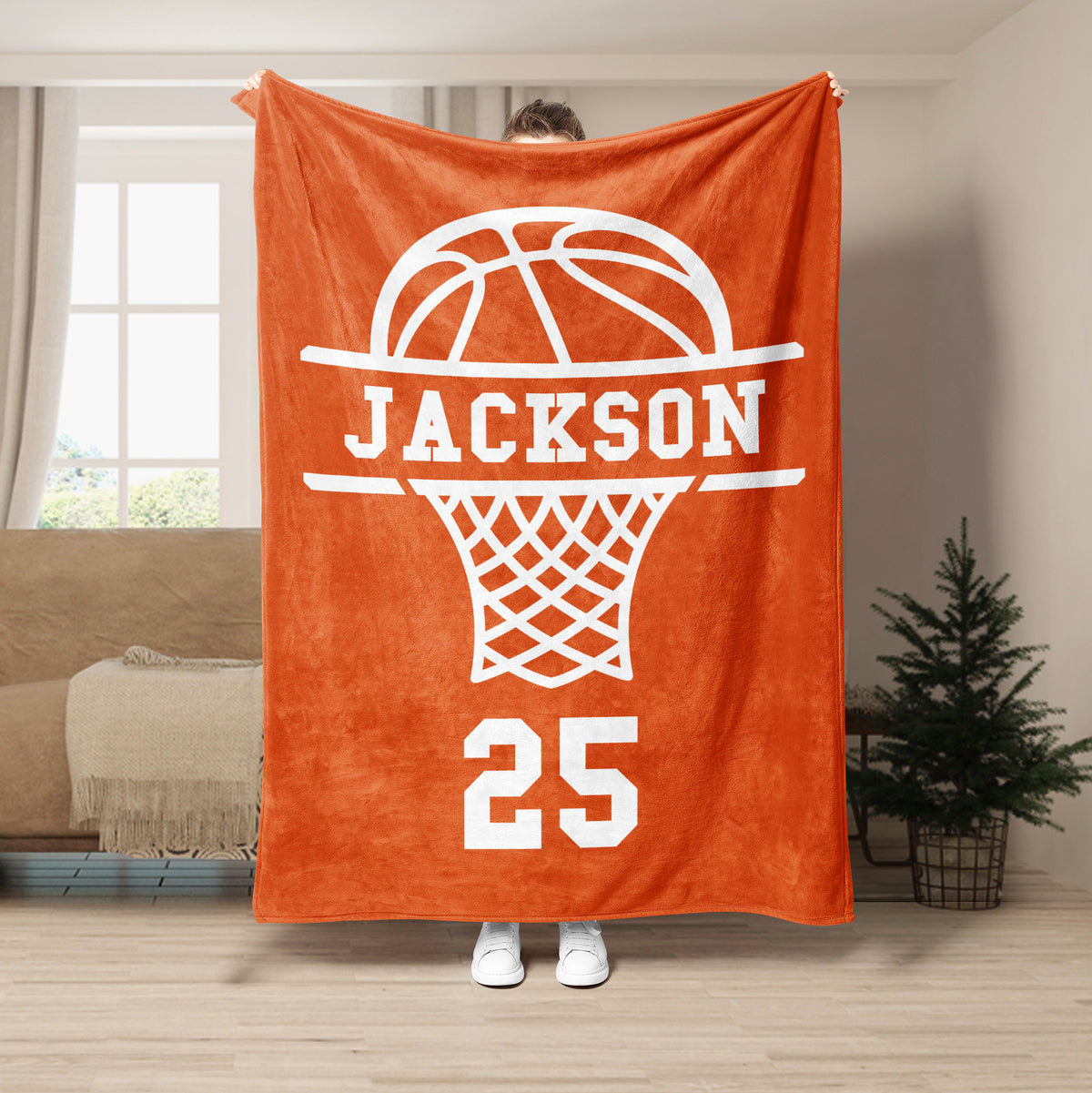 Orange basketball throw blanket displayed in a living room with a bold white hoop graphic