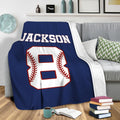 Baseball throw blanket draped over a sofa in a cozy living room with bold navy sports artwork