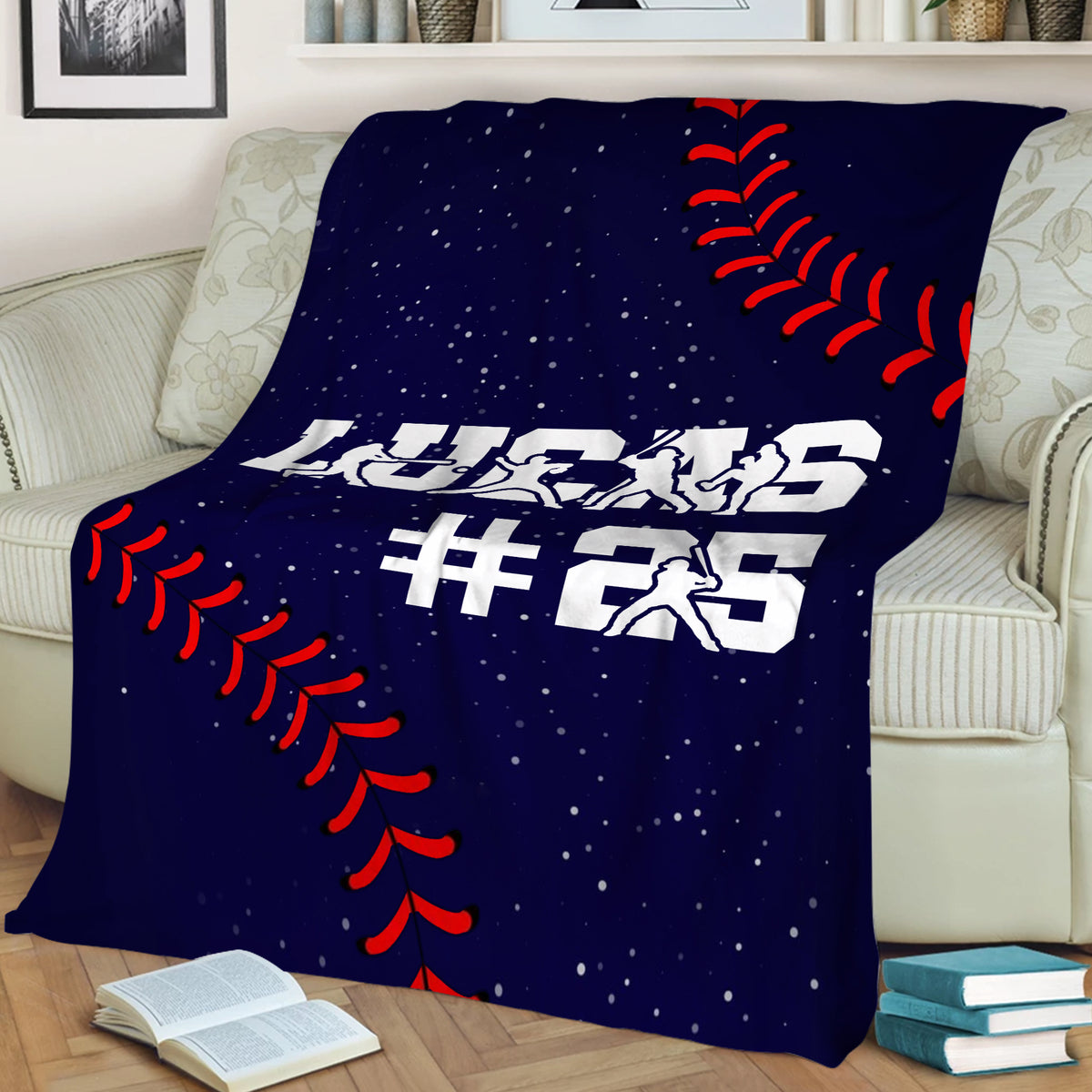 Baseball throw blanket draped over a couch with player silhouettes, red stitching, and navy background