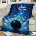 Bowling blanket styled on a couch with bowling pins, black ball, and bold blue flame design