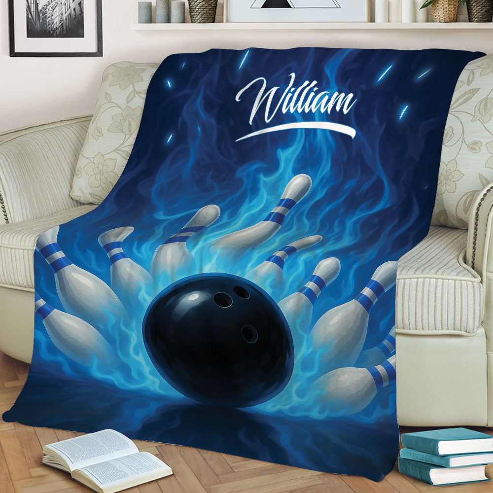 Bowling blanket styled on a couch with bowling pins, black ball, and bold blue flame design