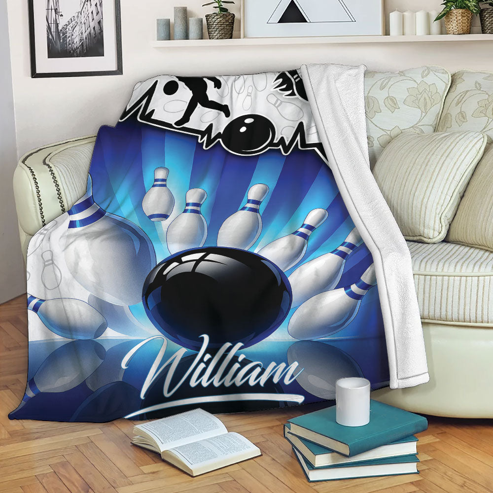 Bowling blanket draped over a sofa with blue bowling ball and pin artwork