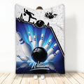 Bowling throw blanket with blue bowling ball and pins artwork displayed by a person
