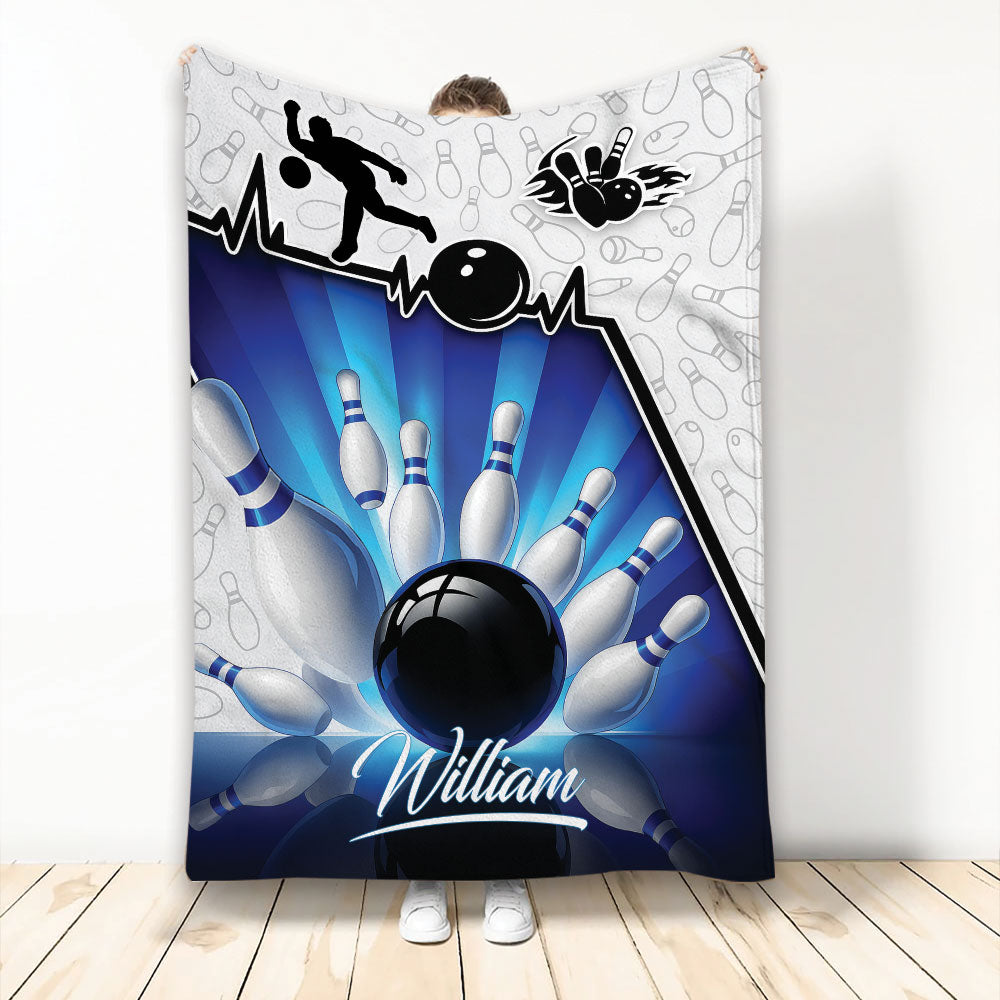 Bowling throw blanket with blue bowling ball and pins artwork displayed by a person