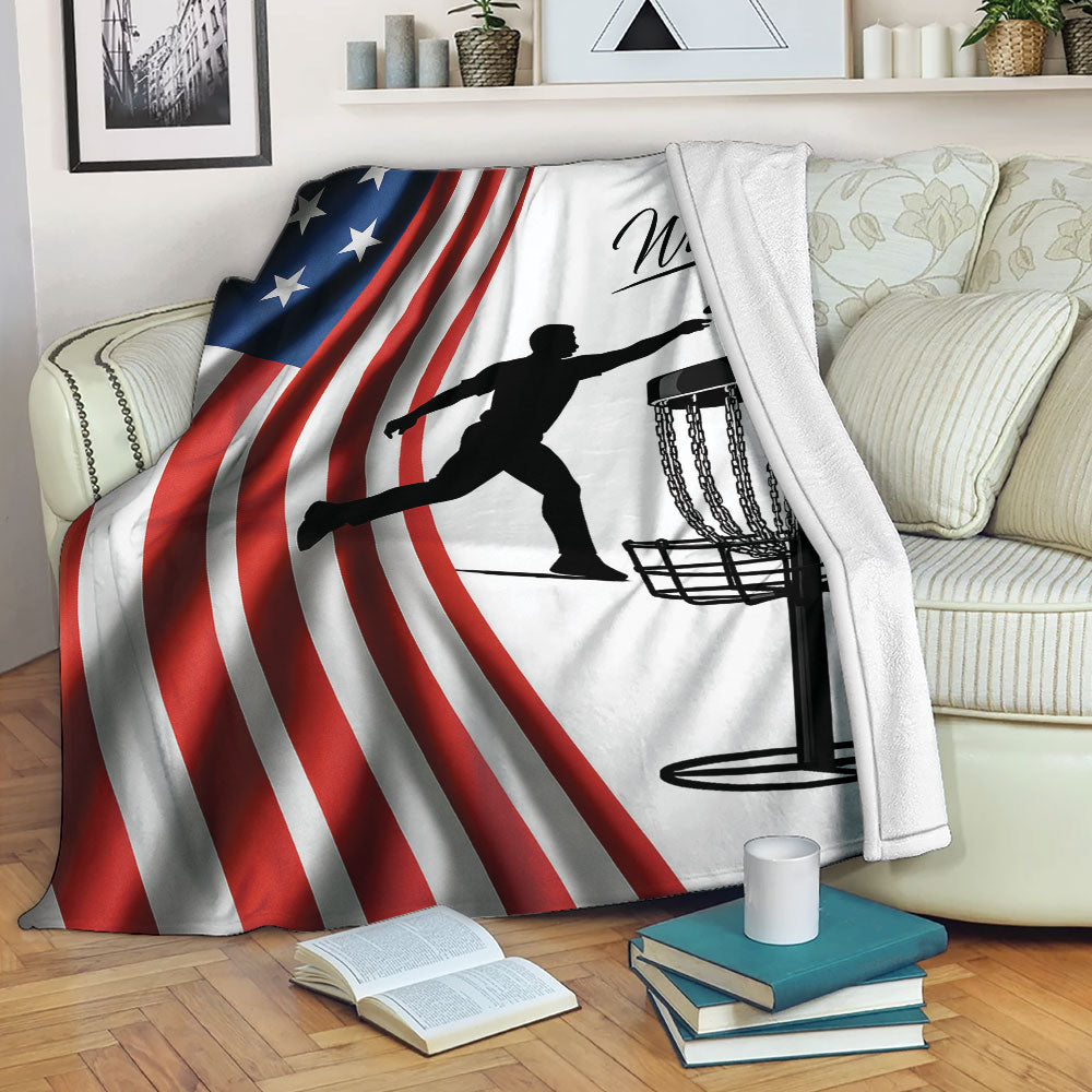 Disc golf throw blanket displayed on a sofa with patriotic flag stripes and basket artwork